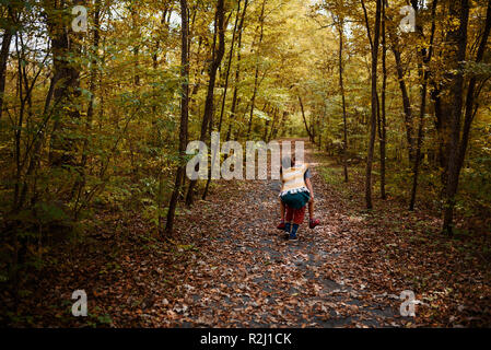 Junge seine Schwester, die ein Huckepack in den Wäldern, United States Stockfoto