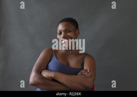 Porträt Lächeln, selbstbewusste Frau mit verschränkten Armen Stockfoto