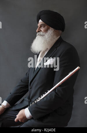 Portrait ernst, gut gekleideter älterer Mann in Turban holding Flöte Stockfoto
