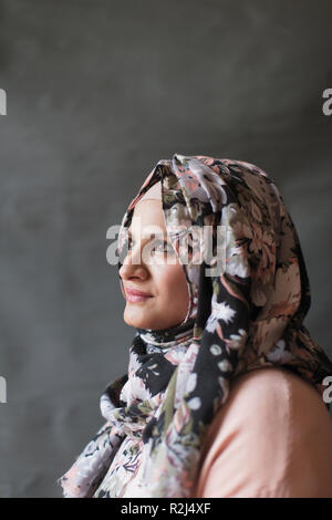 Ruhige, nachdenkliche Frau in floralen Hijab suchen Stockfoto