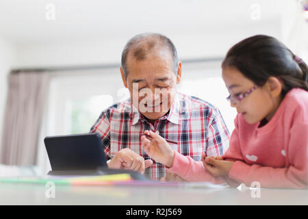 Großvater und Enkelin Färbung und Verwendung digitaler Tablet Stockfoto