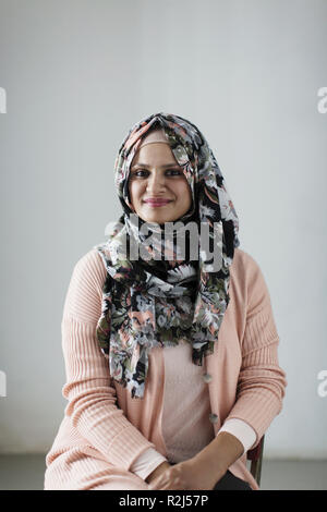 Porträt Lächeln, selbstbewusste Frau mit floralen Hijab Stockfoto