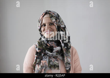 Porträt Lächeln, selbstbewusste Frau mit floralen Hijab Stockfoto