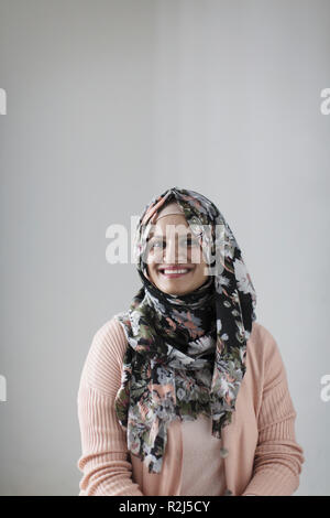 Porträt Lächeln, selbstbewusste Frau mit floralen Hijab Stockfoto