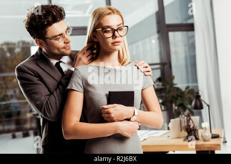Portrait der männlichen Rechtsanwalt Flirten mit Kollege im Büro, Büro Romanze Konzept Stockfoto