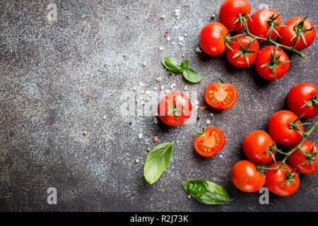 Frische Trauben Tomaten mit Basilikum und grobem Salz, Ansicht von oben mit der Kopie Raum Stockfoto