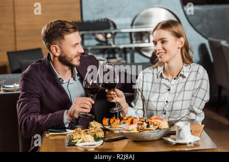 Schönes Paar klirren beim Abendessen in Restaurant Stockfoto