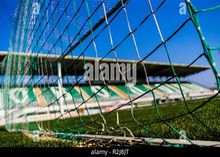 Fußballtor net mit wenig Tribüne auf Hintergrund und bunten Gras und Sky Stockfoto