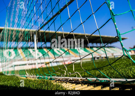 Fußballtor net mit wenig Tribüne auf Hintergrund und bunten Gras und Sky Stockfoto