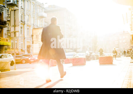 Menschen mit nicht erkennbare Gesichter sind zu Fuß durch die Straßen voll von Abend glänzte warm Stockfoto