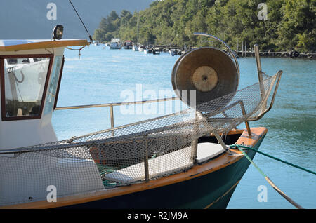 Kleines Fischerboot Bogen mit Morgennebel auf dem Meer in einem Abstand angedockt Stockfoto