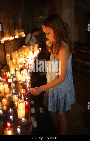 Junge Mädchen die Kerze unter Leitung von Kerzen in der Katholischen Kirche Stockfoto