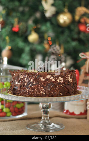 Köstliche frische Schokolade Pistaccio Kuchen mit Schokolade Stück um und Pistazien auf oben auf Glasplatten serviert mit Weihnachten Dekoration Stockfoto