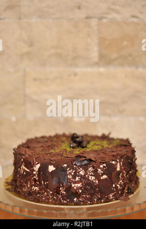 Köstliche frische Schokolade Pistaccio Kuchen mit Schokolade Stück um und Pistazien auf oben auf Glasplatten serviert mit Weihnachten Dekoration Stockfoto