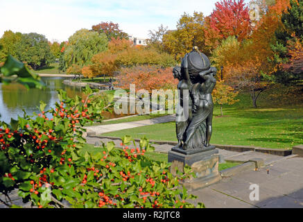 Die Bronzestatue, Nacht, die Erde zu Tag, von Frank Jirouch ist von bunten Herbstlaub in Wade Park in Cleveland, Ohio, USA umgeben. Stockfoto