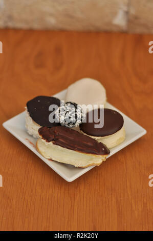 Frische und köstliche kleine Mix eclairs, cremige Kuchen Stockfoto