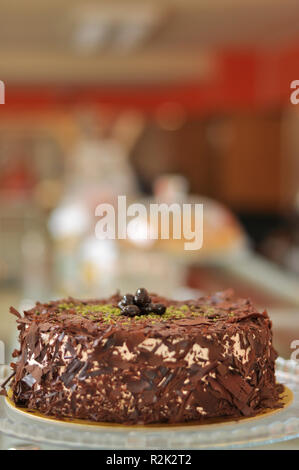 Köstliche frische Schokolade Pistaccio Kuchen mit Schokolade Stück um und Pistazien auf oben auf Glasplatten serviert mit Weihnachten Dekoration Stockfoto