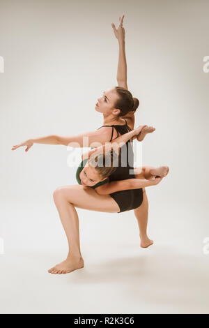 Die beiden modernes Ballett Tänzer tanzen auf Grau studio Hintergrund Stockfoto