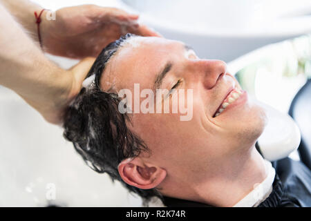 Nahaufnahme einer jungen kaukasischen Mann sein Haar in einem Friseursalon gewaschen. Stockfoto