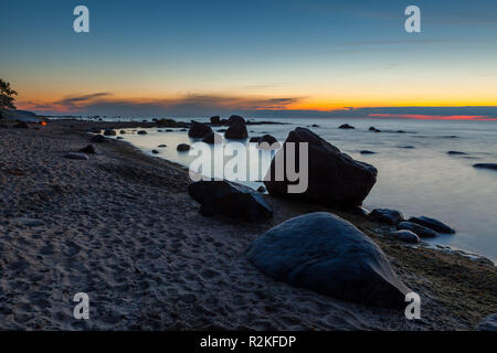 An der felsigen Küste des Meeres mit dem Felsbrocken. Am Abend nach dem Sonnenuntergang. Stockfoto