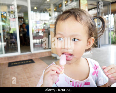 Selektiver Fokus kleine asiatische Mädchen glücklich ist ein leckeres Eis zu essen, zu kopieren. Stockfoto