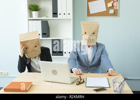 Business, Emotionen und Personen Konzept - Zwei wütend und erschöpft Arbeitnehmer am Arbeitsplatz. Menschen tragen die Pakete auf ihre Köpfe mit abgebildeten emo Stockfoto