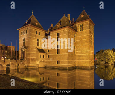 Beleuchtete 12. Jahrhundert renoviert Schloss durch Wasser in der Nacht, Europa umgeben. Stockfoto