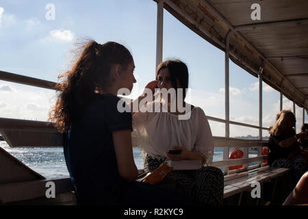 Zwei junge Frauen sitzen auf einer Fähre von der Asiatischen Seite auf der europäischen Seite von Istanbul. Es ist ein sonniger Sommertag. Stockfoto