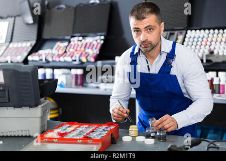 Fokussierte männlichen Arbeitnehmers herauf Farbe von Fasern für Autositze in Werkstatt Stockfoto