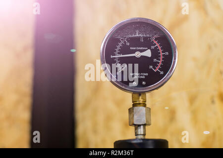 Hydraulikpresse analoge Messuhr und osb auf Hintergrund mit Kreativen lens flare Stockfoto