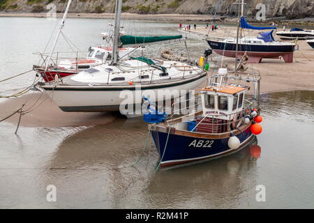 Eine kleine Hummer Fischereifahrzeug ist bei Ebbe, New Quay, Wales, Ceredigion Stockfoto