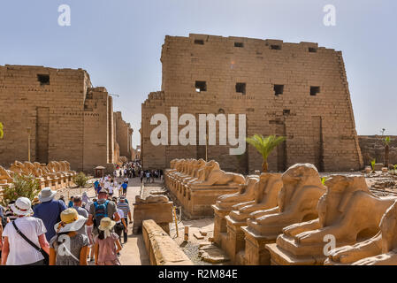 Touristen zu Fuß die Prozession mit RAM-headed sphinxs gegen pylon I und II, Karnak, Luxor, Ägypten, 22. Oktober 2018 Stockfoto