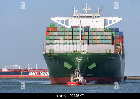 ROTTERDAM, Niederlande - 16. FEBRUAR 2018: Die großen Container schiff Thalassa Mana ist von einem Schlepper bei seiner Ankunft an der Maasvlakte, Hafen von begleitet Stockfoto