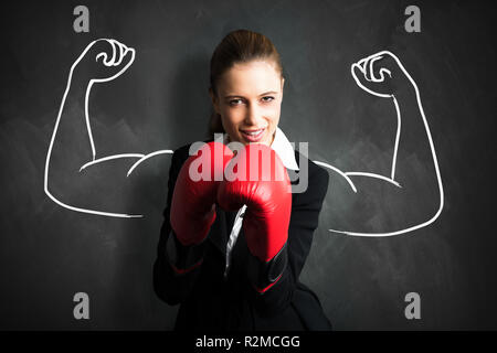 Attraktive Geschäftsfrau mit Boxhandschuhen für einen Kampf bereit Stockfoto