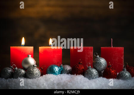 Weihnachten Kugeln und zwei von vier Kerzen im Schnee Stockfoto