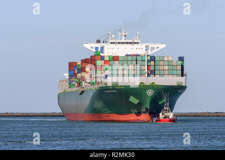 ROTTERDAM, Niederlande - 16. FEBRUAR 2018: Die großen Container schiff Thalassa Mana ist von einem Schlepper begleitet, wie es auf der Maasvlakte, Hafen von Eintrifft Stockfoto