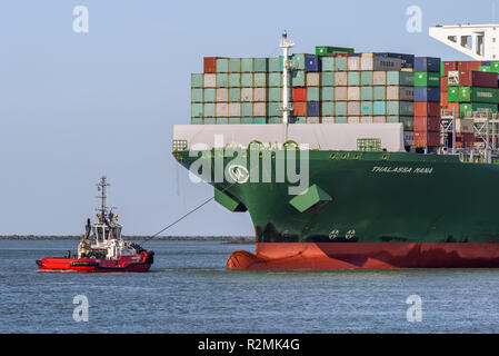 ROTTERDAM, Niederlande - 16. FEBRUAR 2018: Die großen Container schiff Thalassa Mana ist von einem Schlepper bei seiner Ankunft an der Maasvlakte, Hafen von begleitet Stockfoto