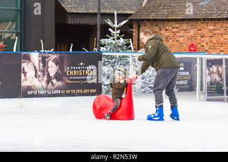 Gloucester, Gloucestershire, Vereinigtes Königreich. 19 Nov, 2018. Gloucester Quays preisgekrönte Viktorianische Weihnachten Markt, dem größten freien Eintritt im Viktorianischen Weihnachtsmarkt im Südwesten. Junge sitzt auf der Beluga Whale Kinder skate Aids durch man Schlittschuhlaufen auf der Eisbahn im Freien geschoben werden. Credit: Carolyn Jenkins/Alamy leben Nachrichten Stockfoto