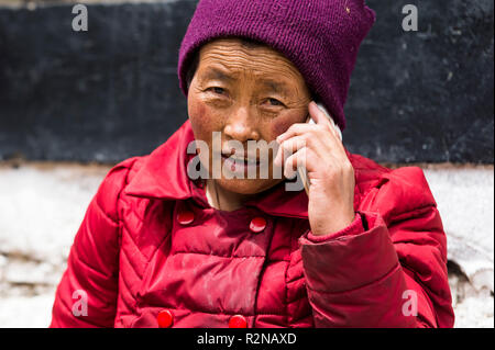 Tsethang, Altstadt, Frau Reden auf dem Smartphone, Porträt Stockfoto