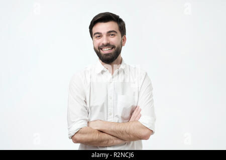 Portrait von lächelnden gutaussehenden Mann im weißen Hemd mit verschränkten Armen Stockfoto