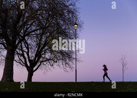 Person Training. Frau Laufen oder Joggen im Park bei Nacht, Nottingham, England, Großbritannien Stockfoto