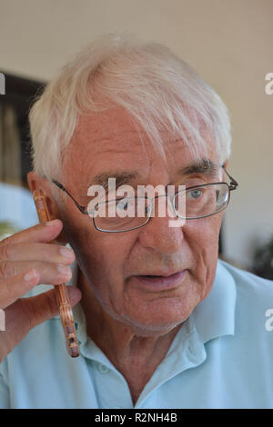 Älterer Mann auf einem Mobiltelefon, suchen Betroffene Stockfoto