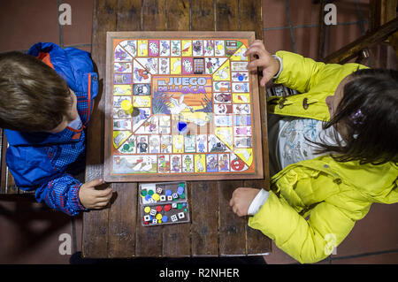 Kleine Brüder spielen Spiel der Gans über Holz- vintage Tabelle. Ansicht von oben. Traditionelle brettspiel Stockfoto