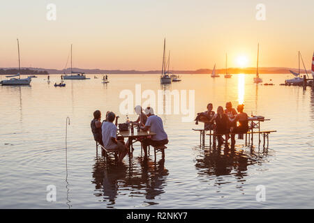 Tabellen im Wasser, Sundowner Bar in Übersee am Chiemsee, Chiemgau, Oberbayern, Bayern, Süddeutschland, Deutschland, Europa Stockfoto