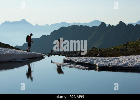 Wanderer zu einem namenlosen See in Riegetal Tal, Geigenkamm, Ötztaler Alpen, Tirol, Österreich Stockfoto