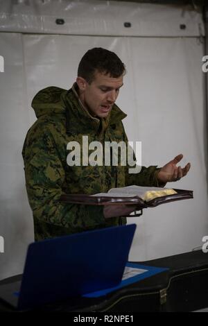 Us Navy Lieutenant Nathanael Gentilhomme, Links, der Kaplan der Bekämpfung der Logistik Bataillon 2 (CLB2) führt, Marinesoldaten und Matrosen mit Clb2 und 2nd Marine Division in Hymnen in Voll, Norwegen, Okt. 28, 2018. Die religiöse Ministerien team Angeboten evangelische und katholische Dienstleistungen, Marines mit Bibelarbeiten und Angeboten wöchentliche Freizeit Sitzungen während der Übung Trident Zeitpunkt 18. Die Übung verbessert die USA und die NATO-Verbündeten und Fähigkeiten der Partner zur Zusammenarbeit militärische Operationen unter schwierigen Bedingungen durchzuführen. Stockfoto