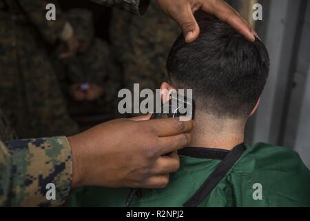 Us Marine Corps Sgt. Shaine Phillips mit 2 Intelligenz Bataillon, II Marine Expeditionary Force Information Group Schnitte Marines Haar während der Übung Trident Punkt 18 am Vaernes Air Station, Norwegen, Nov. 4, 2018. Trident Punkt 18 erweitert die USA und die NATO-Verbündeten und Fähigkeiten der Partner zur Zusammenarbeit militärische Operationen unter schwierigen Bedingungen durchzuführen. Stockfoto