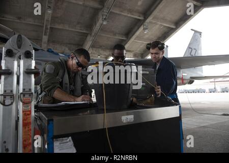 Us Air Force Piloten aus der 44th Fighter Squadron und 44 Aircraft Maintenance Unit schreiben Post-flight Schreibarbeit Nov. 1, 2018, bei Kadena Air Base, Japan. Kadena AB ist der Grundpfeiler der Pazifik, Unterstützung mehrerer Zellen, einschließlich der F-15C Eagle, und wertvolle Agile Combat Beschäftigung Fähigkeiten im Pazifik. Stockfoto