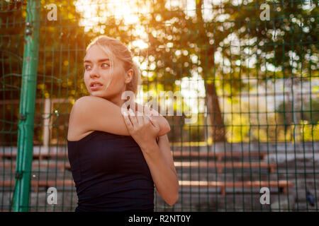 Junge Sportlerin aufwärmen, bevor Sie am Sportplatz im Sommer. Sportliche Frauen stretching Körper. Aktiven Lebensstil Stockfoto