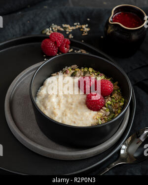 Frühstück Haferbrei mit Früchten und Nüssen in Einstellung dunkel Stockfoto